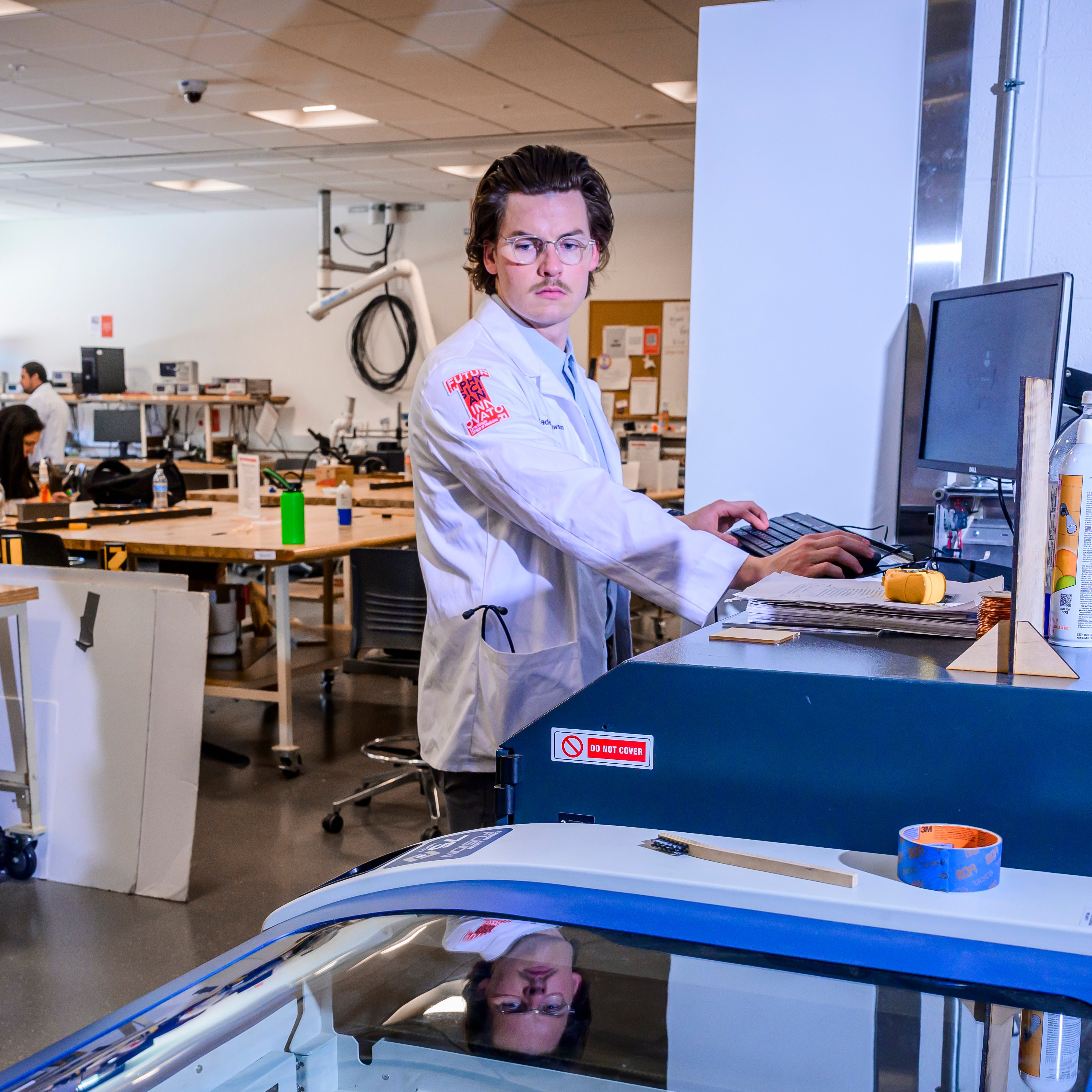 Kaden Rawson (CI MED Class of 2025) is pictured with a computer working on a project in a lab.