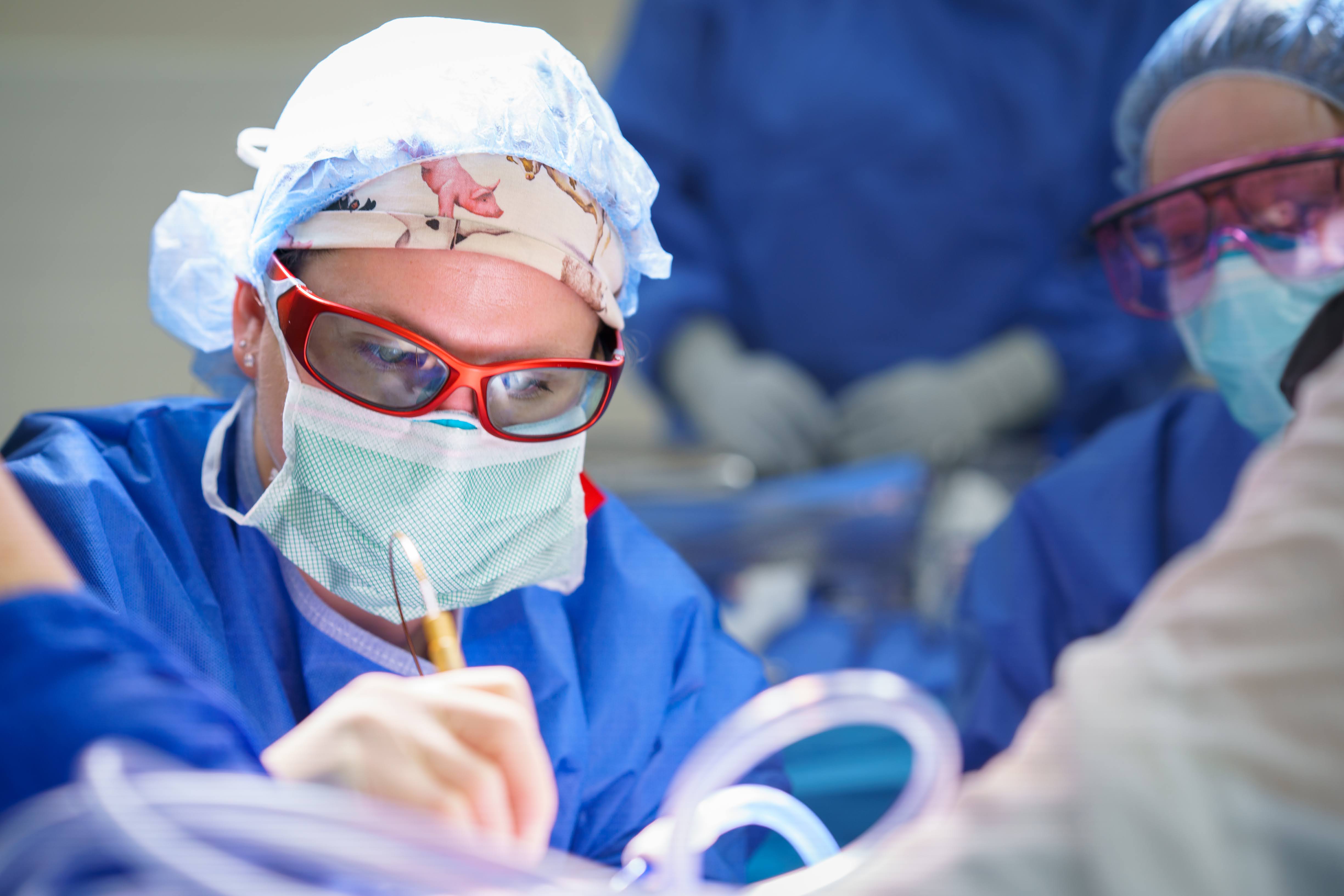 Close-up of Dr. Megan Hutchcraft in blue surgical scrubs and goggles during surgery.