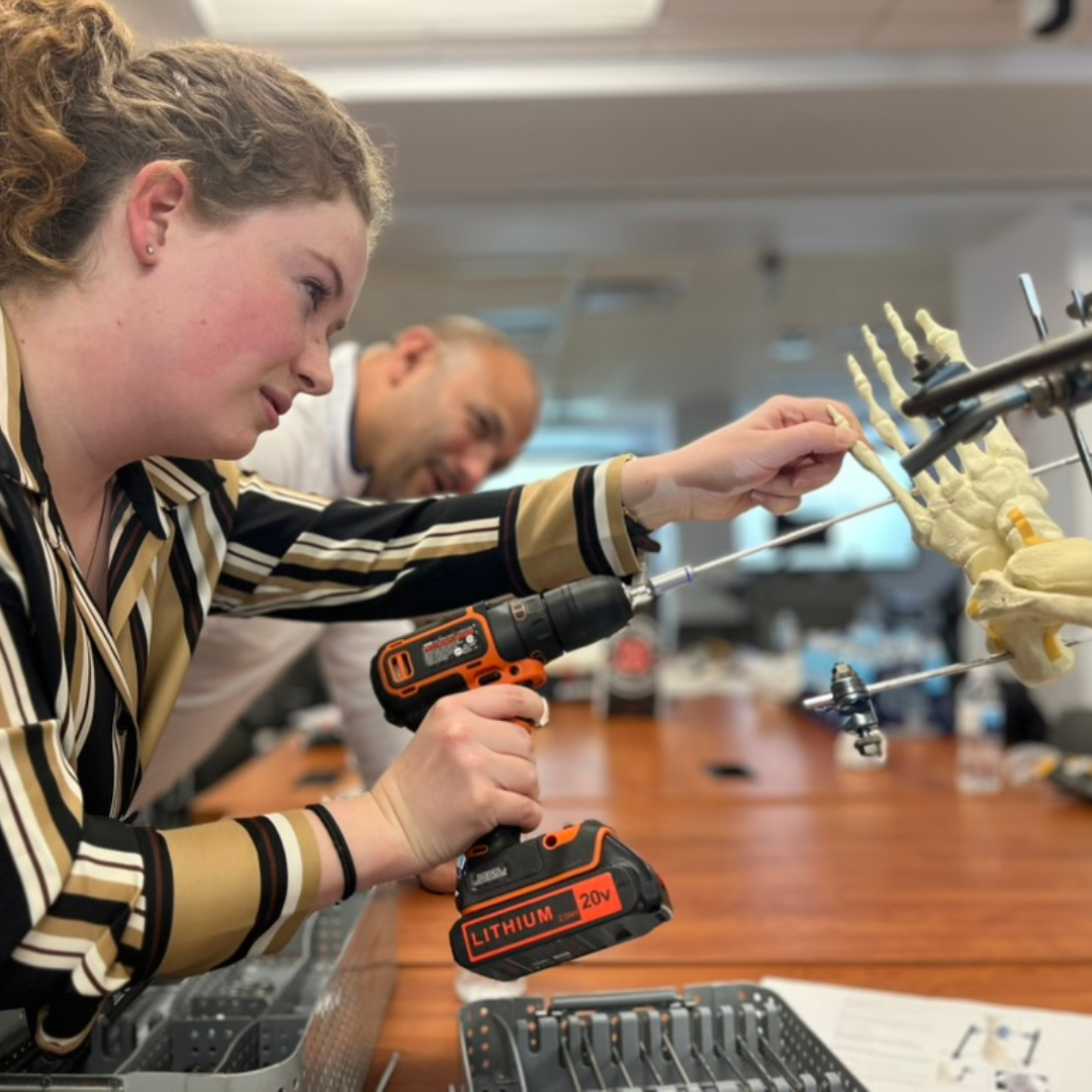 Aleksandra Katilius practices orthopedic surgery techniques on a model of a human extremity. The workshop included hands-on practice with external fixation procedures.