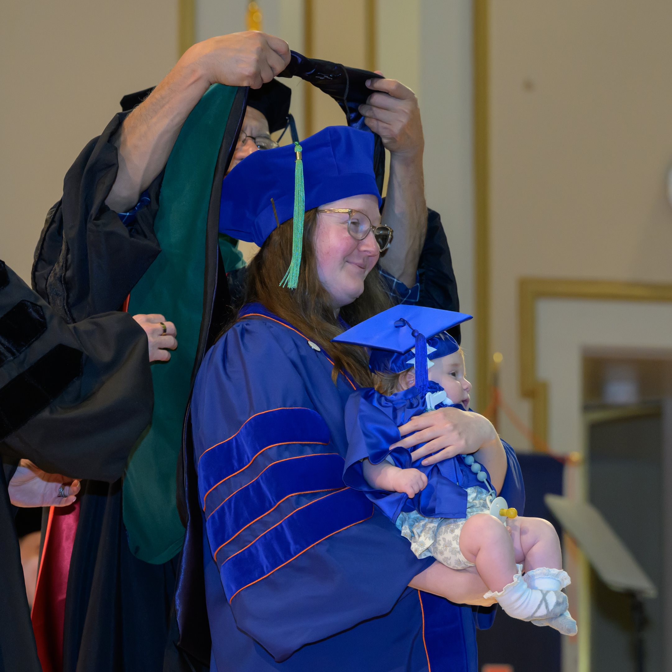 <em>Dr. Maxine Arnush and baby took the stage during the hooding ceremony.</em>