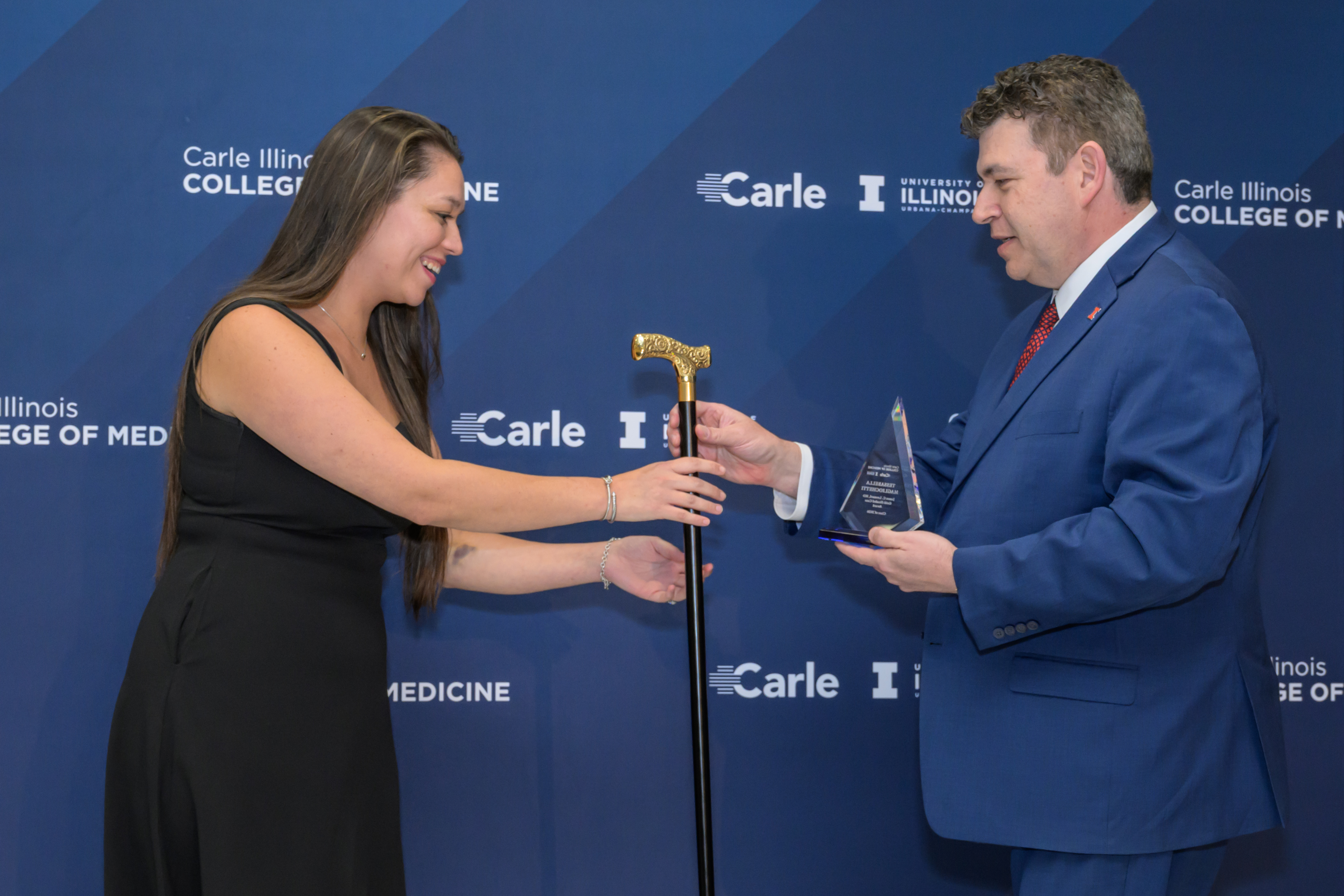 Tessabella Magliochetti (left) is pictured receiving the gold headed cane as the 2026 recipient of the James C. Leonard, MD, Gold-Headed Cane Award honoring outstanding commitment to patient care. DeanÂ MarkÂ Cohen is presenting theÂ award.