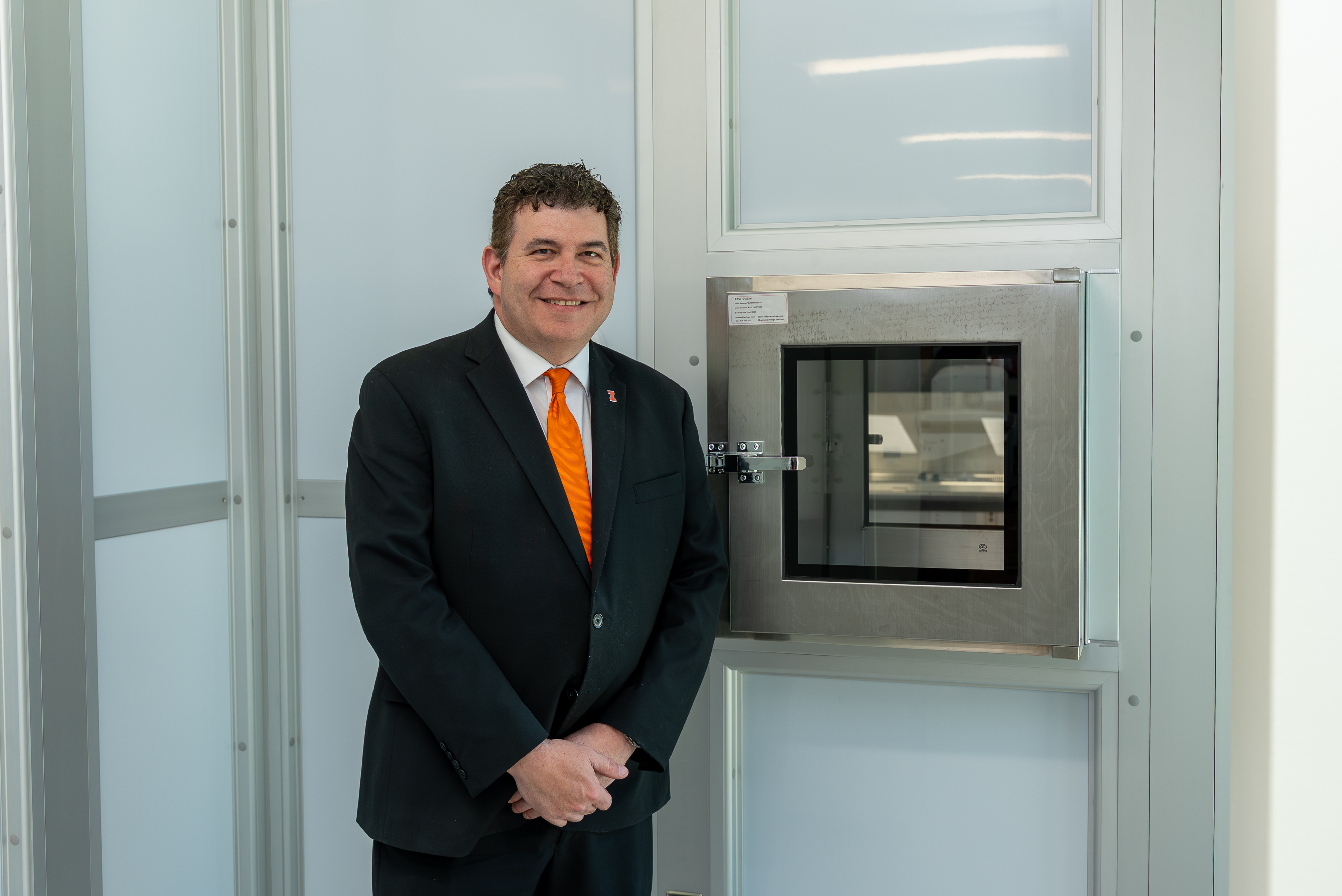 photo of carle illinois college of medicine dean mark cohen smiling as he stands beside a secure enty point at the entrance of the Translational Oncology and Regenerative Medicine Laboratory housed at the beckman institute