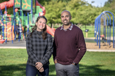 Two professors standing in front of a playground