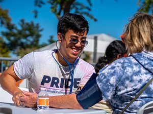 Nic Nguyen, a second year student and aspiring family medicine physician, volunteers at the Carle Illinois vitals station where he and fellow students provided free health screenings and measured vital signs for participants at the 2022 Urbana Pride Festival.