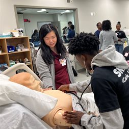 Third-year medical student Joanne Chan leads AVID students through a heart and lung sounds workshop.