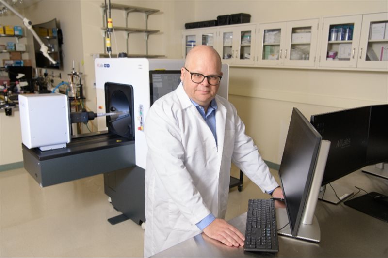Wawrzyniec Dobrucki, the Neil and Carol Ruzic Faculty Scholar and a Health Innovation Professor at Carle Illinois College of Medicine, and an associate professor of bioengineering, pictured with the ultra-high performance PET-CT scanner at the U of I's Beckman Institute.